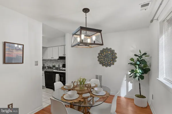 a dining room with furniture a chandelier and wooden floor