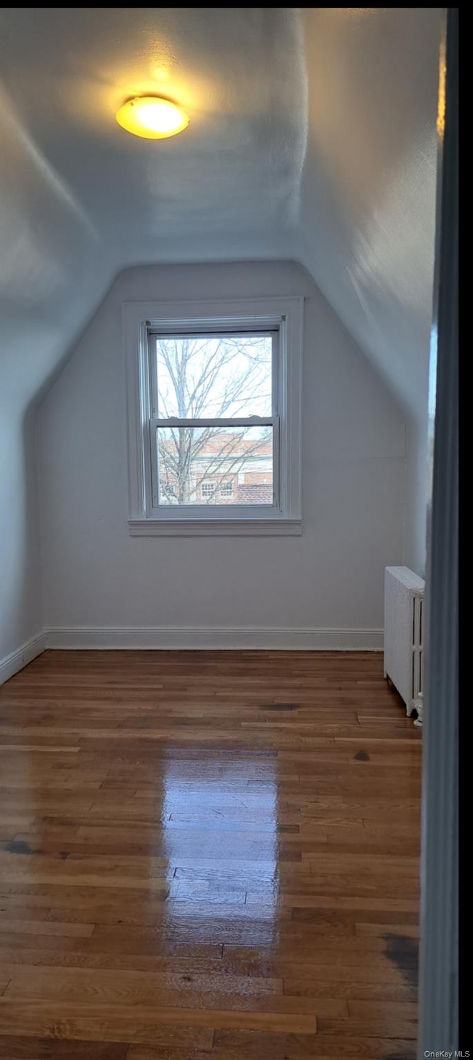 141 Sterling Avenue Yonkers, NY 10704 - Photo 21 of 23 a view of an empty room with wooden floor and a window
