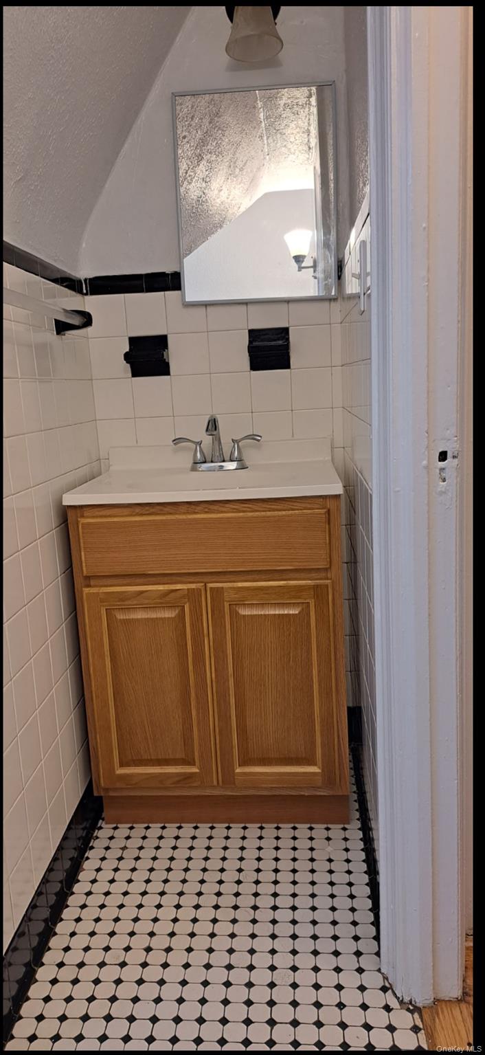 141 Sterling Avenue Yonkers, NY 10704 - Photo 22 of 23 a bathroom with a sink a vanity and a mirror