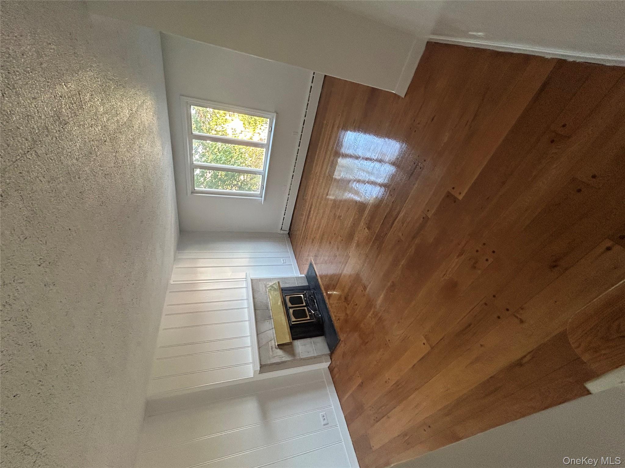 141 Sterling Avenue Yonkers, NY 10704 - Photo 6 of 23 a view of an empty room with window and fireplace