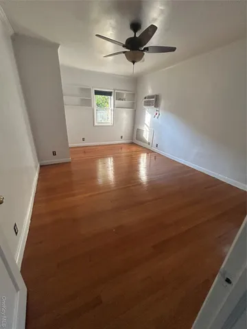 an empty room with windows and ceiling fan