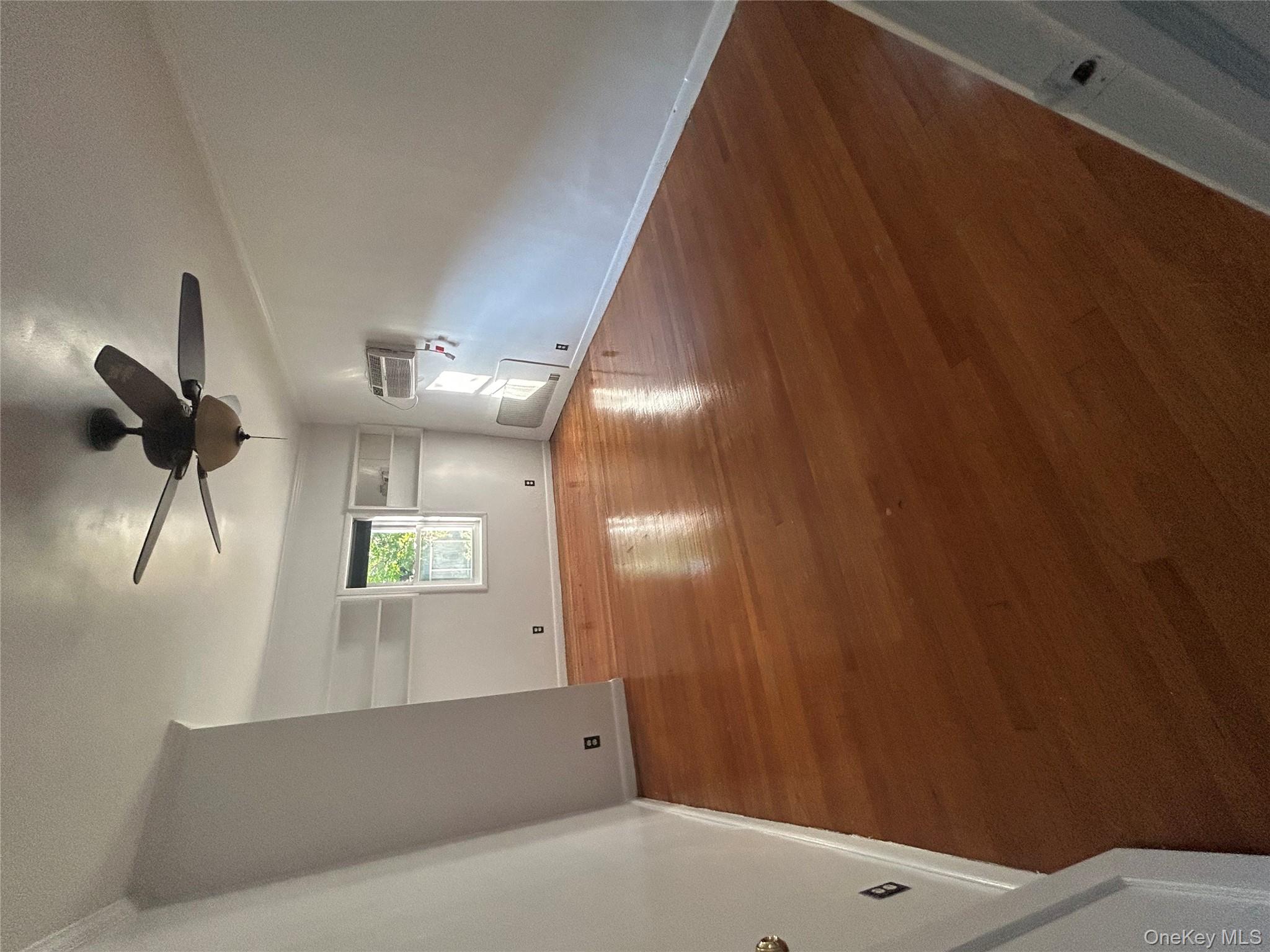 141 Sterling Avenue Yonkers, NY 10704 - Photo 8 of 23 an empty room with windows and ceiling fan