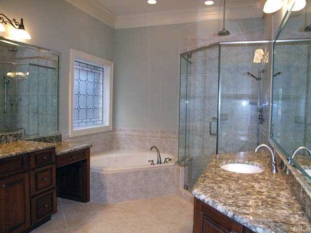 4188 English Garden Way Raleigh, NC 27612 - Photo 14 of 25 Luxuriously appointed with solid wood cabinetry, granite and custom tile detail.