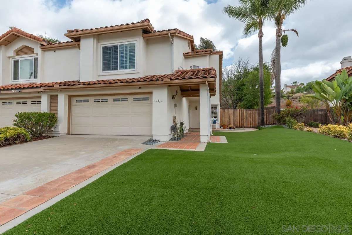 a view of a house with a yard and a garage
