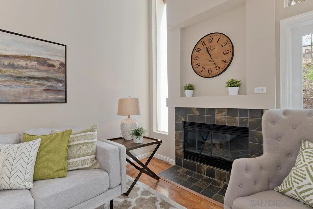 12515 Spindletop Road San Diego, CA 92129 - Photo 18 of 32 a living room with furniture a clock and a fireplace
