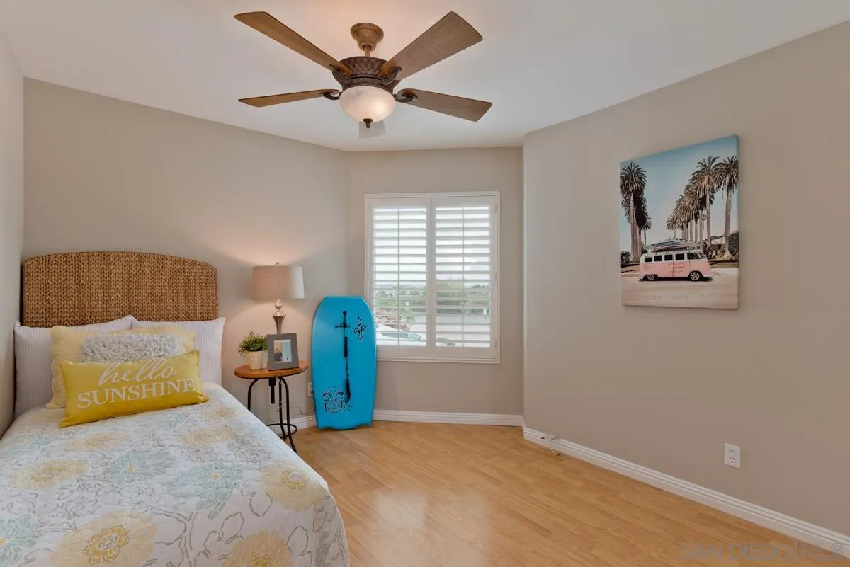 12515 Spindletop Road San Diego, CA 92129 - Photo 22 of 32 a bedroom with a large bed and a chandelier