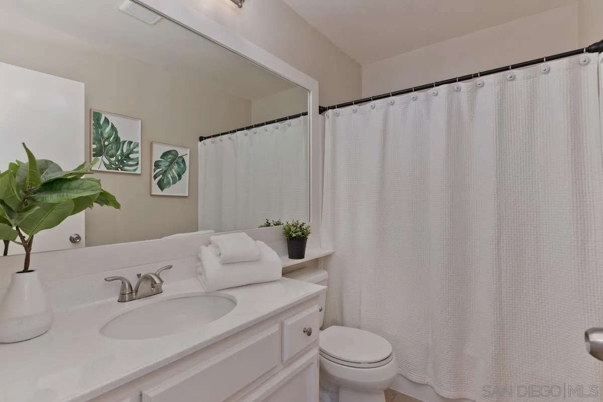 12515 Spindletop Road San Diego, CA 92129 - Photo 23 of 32 a bathroom with a granite countertop sink and a mirror