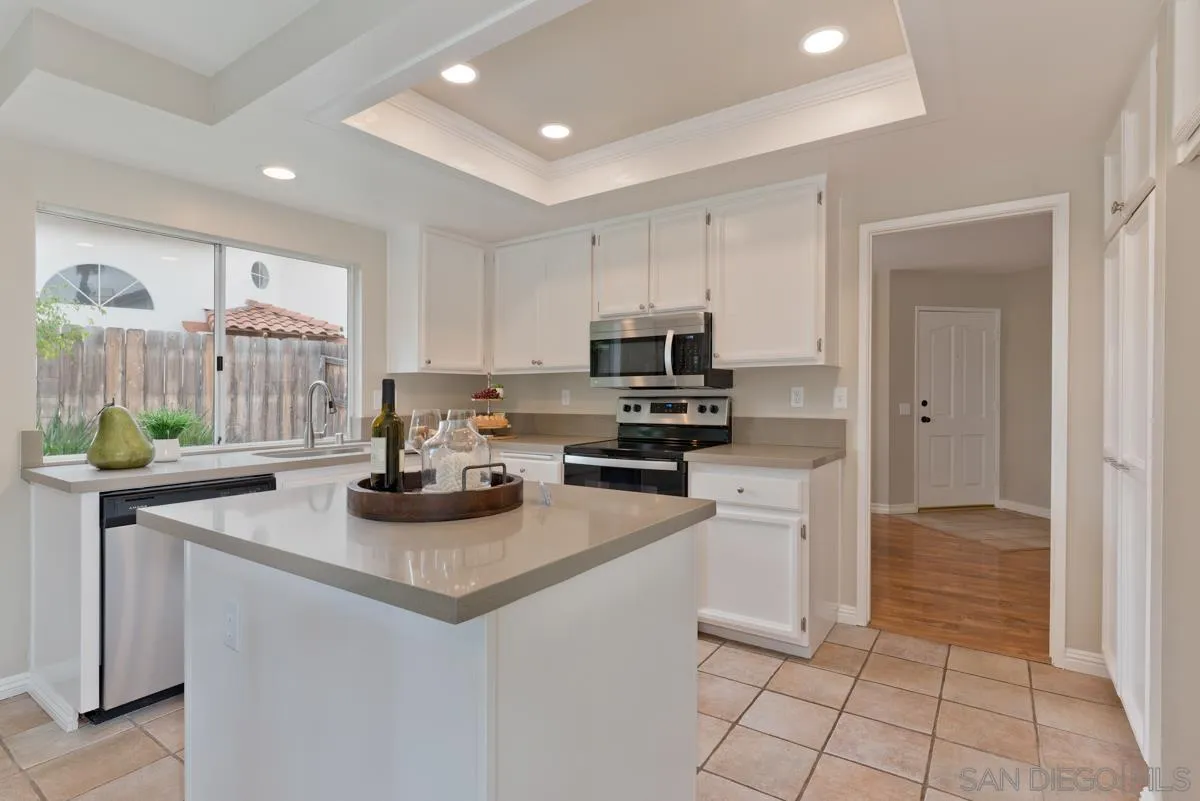 12515 Spindletop Road San Diego, CA 92129 - Photo 7 of 32 a kitchen with sink a refrigerator and microwave