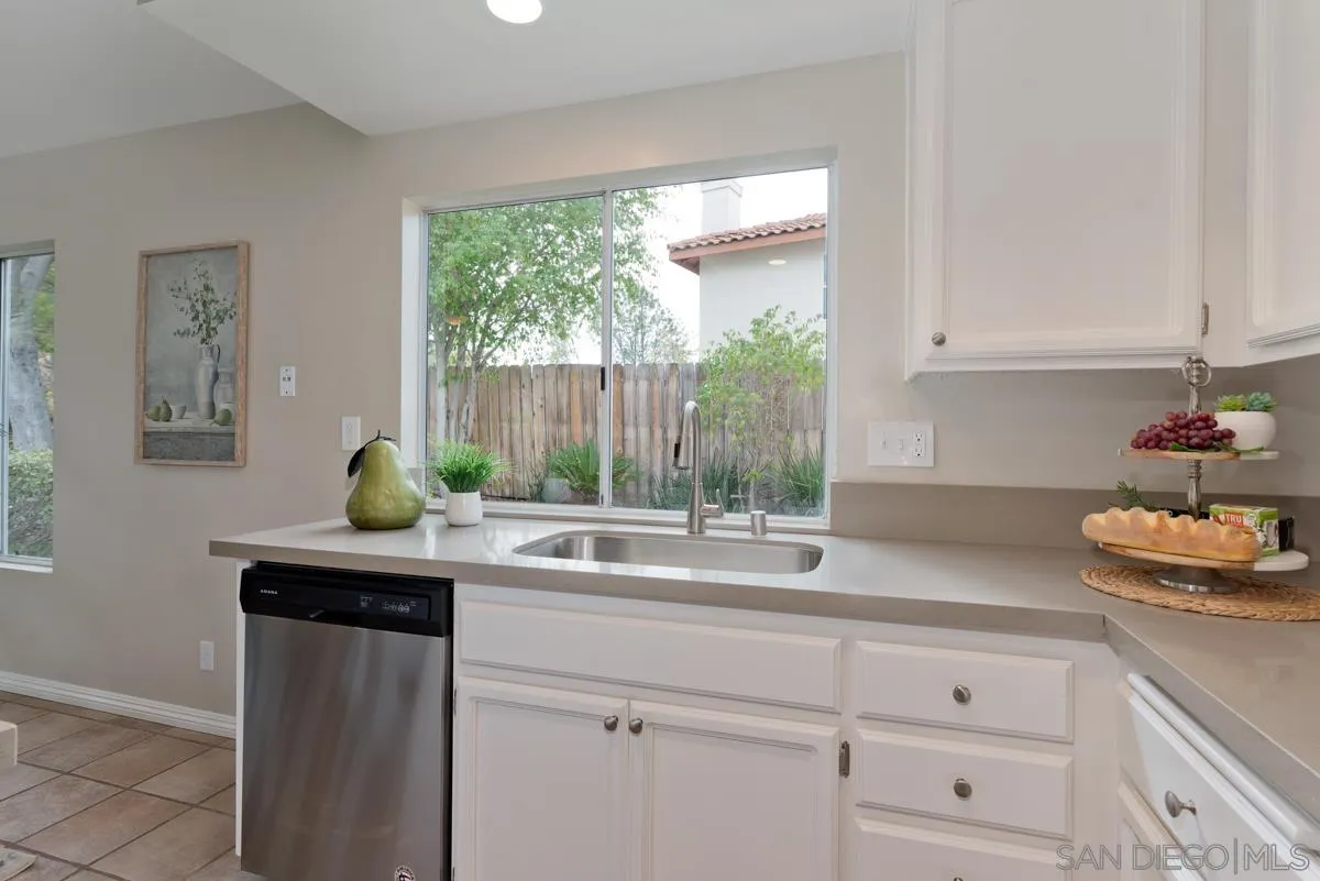 12515 Spindletop Road San Diego, CA 92129 - Photo 8 of 32 a kitchen with stainless steel appliances white cabinets and a window
