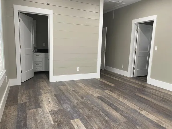 a view of a room with an empty space and wooden floor
