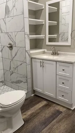 a bathroom with a sink a toilet and shower
