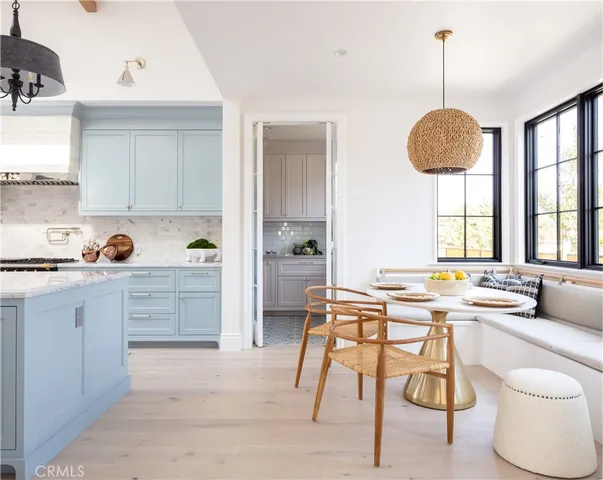 a kitchen with white cabinets and window