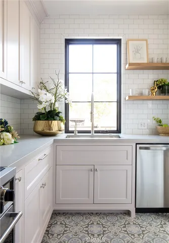 a kitchen with stainless steel appliances white cabinets and a stove a sink