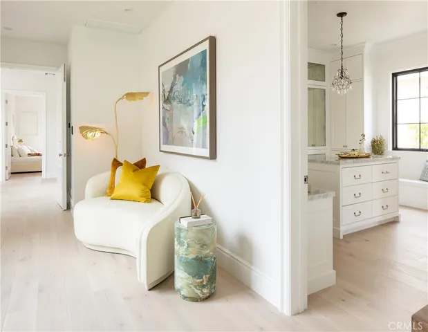 a living room with furniture a chandelier and a bookshelf