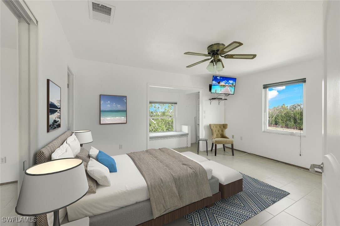 8151 Moyer Lane Bokeelia, FL 33922 - Photo 13 of 49 a bedroom with a bed and a chair