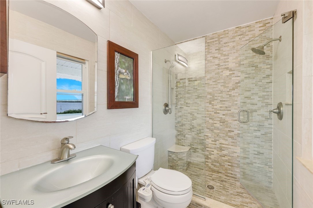 8151 Moyer Lane Bokeelia, FL 33922 - Photo 14 of 49 a bathroom with a sink a toilet and shower