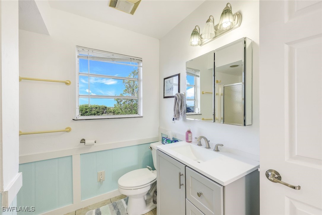 8151 Moyer Lane Bokeelia, FL 33922 - Photo 18 of 49 a bathroom with a sink mirror vanity and toilet
