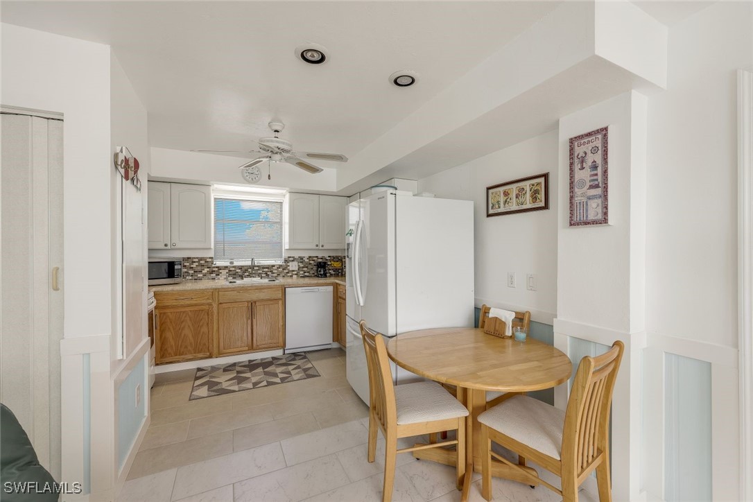 8151 Moyer Lane Bokeelia, FL 33922 - Photo 7 of 49 a kitchen with a dining table chairs cabinets and stainless steel appliances