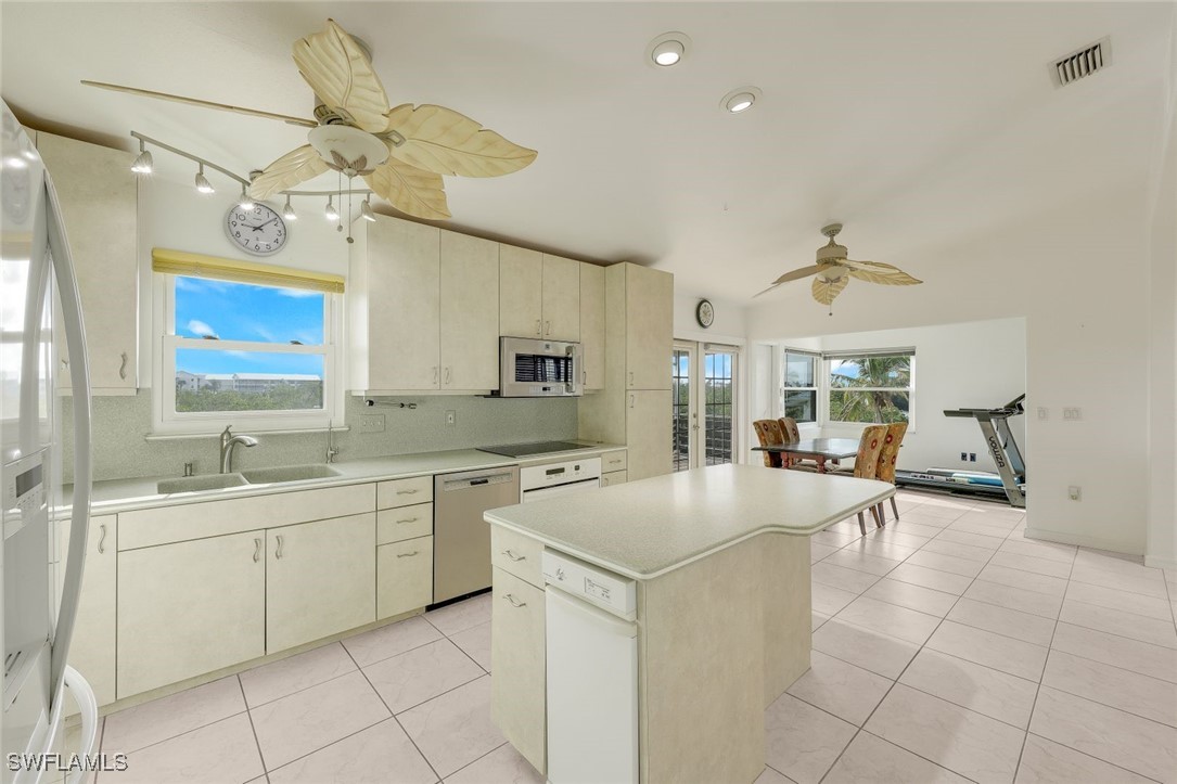 8151 Moyer Lane Bokeelia, FL 33922 - Photo 10 of 49 a large white kitchen with a sink and dishwasher a stove with wooden floor