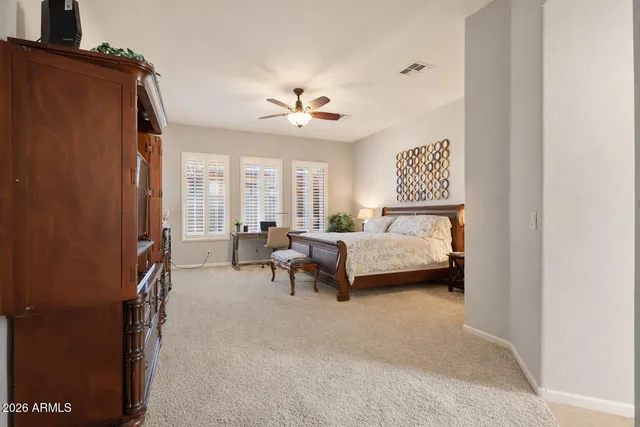 a spacious bedroom with a bed and a chandelier
