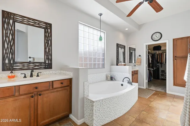 a spacious bathroom with a tub sink and mirror