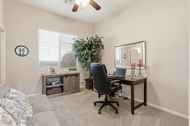 a view of a workspace with furniture and a window