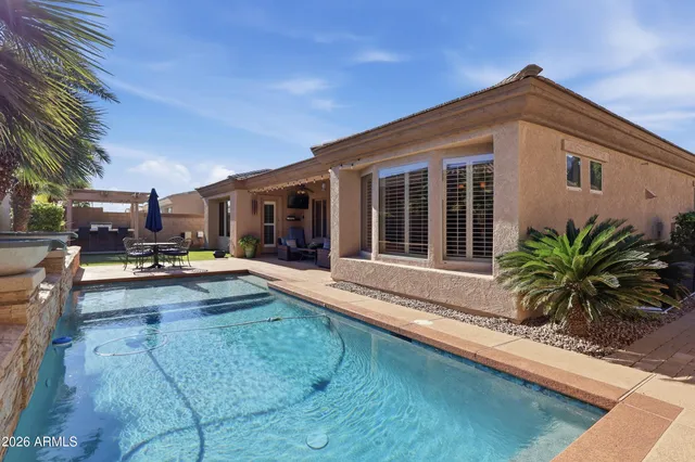 a view of a house with swimming pool and sitting area