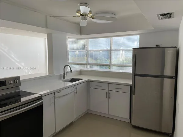 a kitchen with a refrigerator and a sink