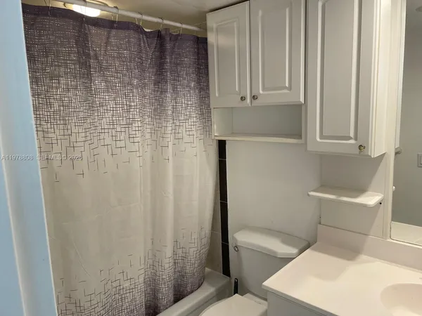a bathroom with a shower curtain and a sink