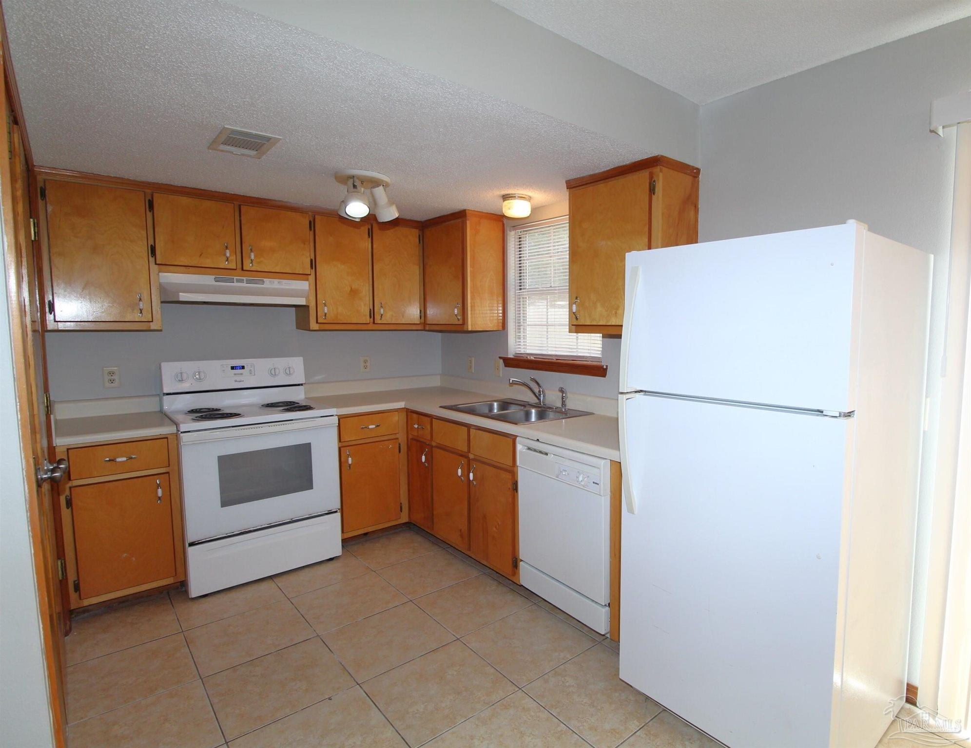 5306 Windham Road Milton, FL 32570 - Photo 4 of 15 a kitchen with a white cabinets and refrigerator