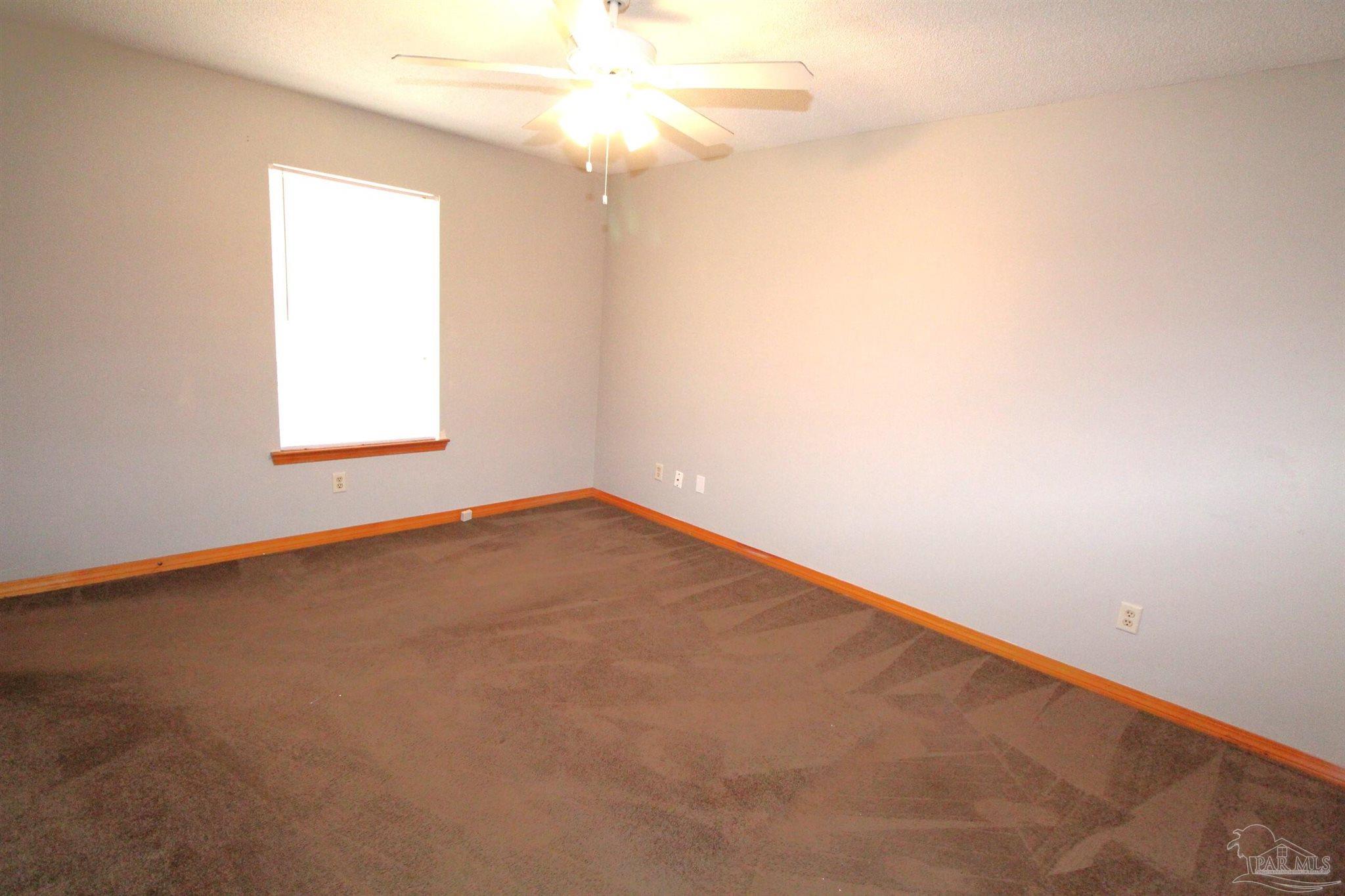 5306 Windham Road Milton, FL 32570 - Photo 5 of 15 an empty room with a window and a fan