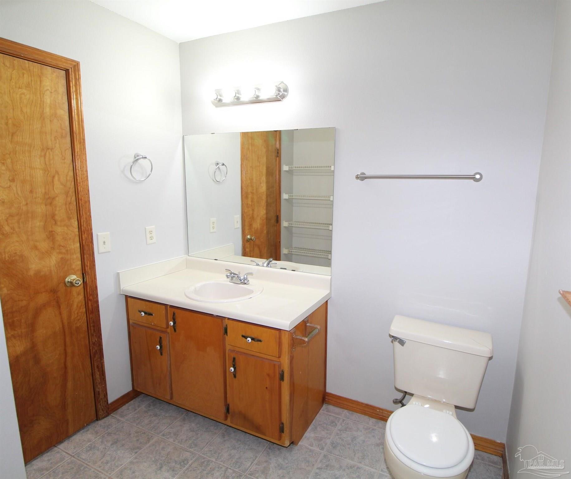 5306 Windham Road Milton, FL 32570 - Photo 9 of 15 a bathroom with a toilet sink and mirror