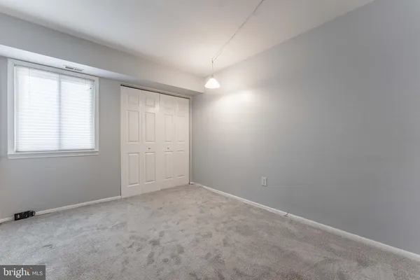 an empty room with windows and closet
