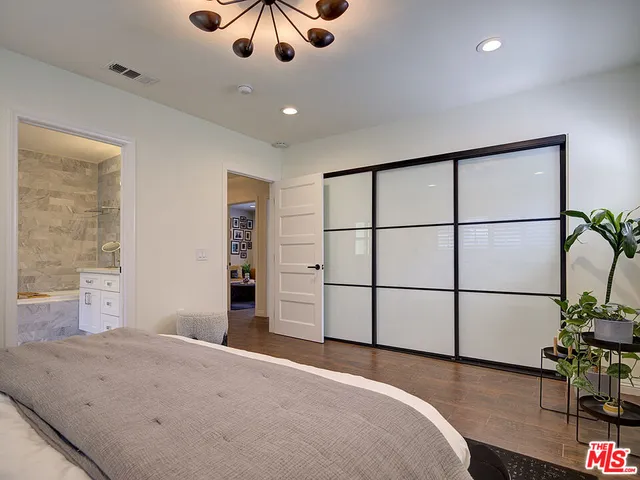 a bedroom with a large bed and a chandelier