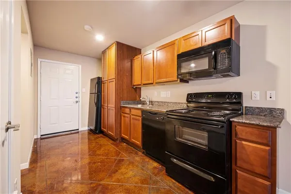 a kitchen with stainless steel appliances granite countertop a stove microwave and refrigerator
