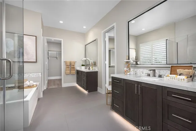 a spacious bathroom with a double vanity sink a mirror and shower