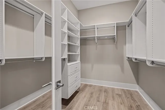 a view of walk in closet with empty racks