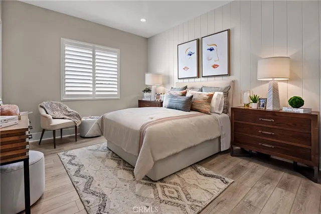 a bedroom with a bed and a lamp on dresser