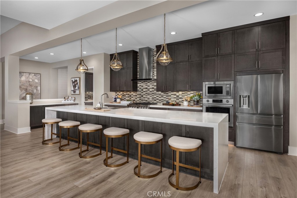 6505 Canyon Oaks Drive Simi Valley, CA 93063 - Photo 5 of 21 a kitchen with stainless steel appliances granite countertop a table chairs stove and refrigerator