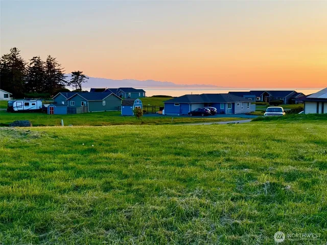 a view of a big house with a big yard and large trees