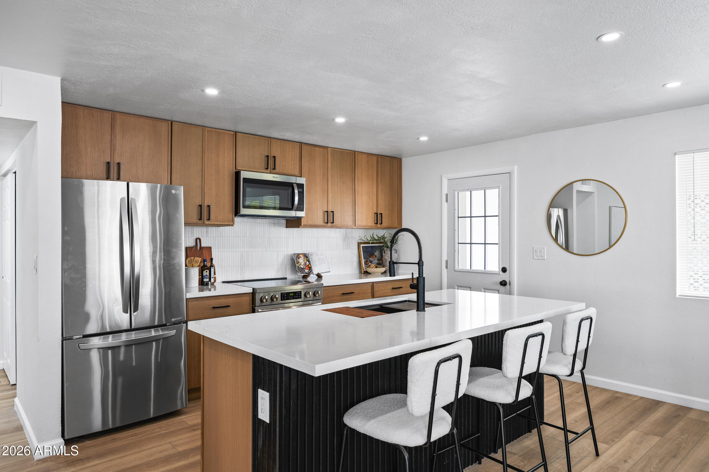 1237 East Ruth Avenue Phoenix, AZ 85020 - Photo 10 of 38 a kitchen with stainless steel appliances a table chairs refrigerator and microwave