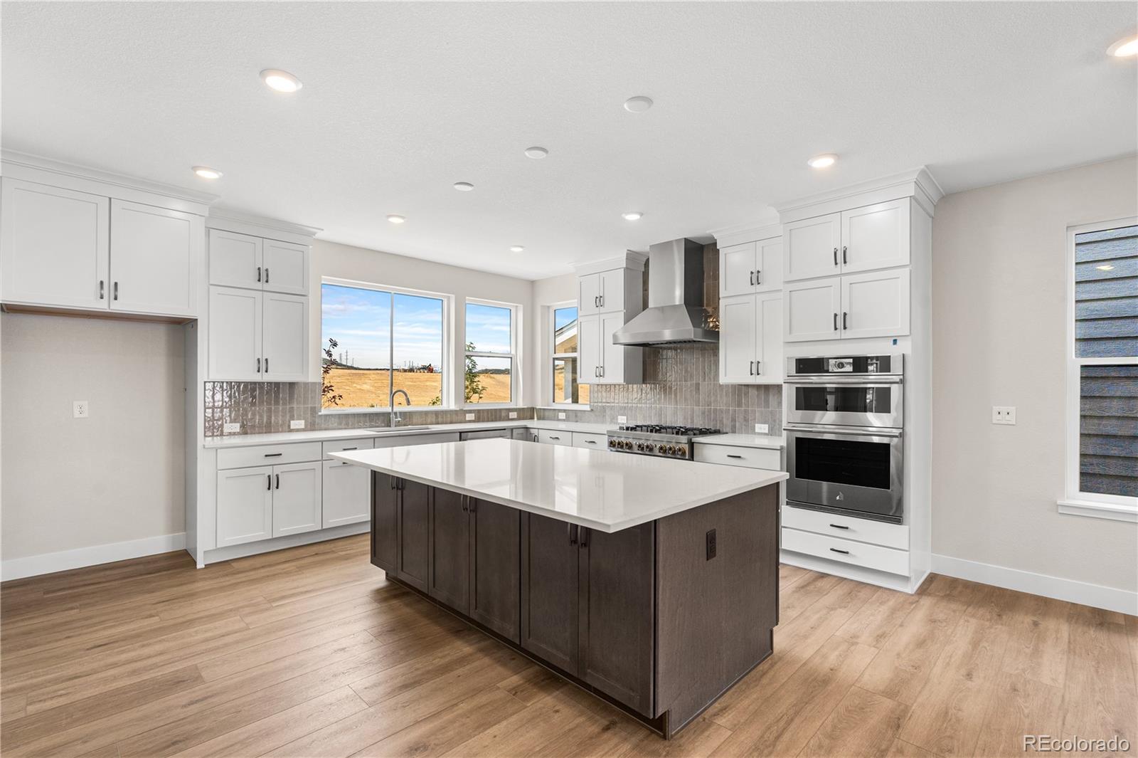11208 Vibrato Lane Lone Tree, CO 80134 - Photo 13 of 40 a large kitchen with cabinets wooden floor and stainless steel appliances