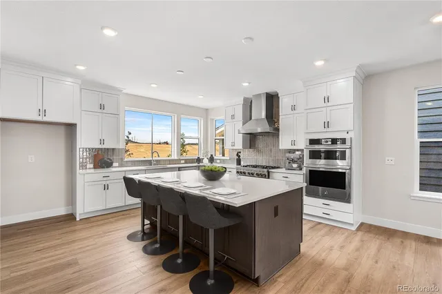 a kitchen with stainless steel appliances granite countertop a table chairs sink refrigerator and cabinets