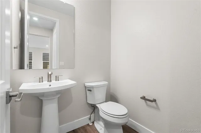 a bathroom with a sink toilet and a mirror