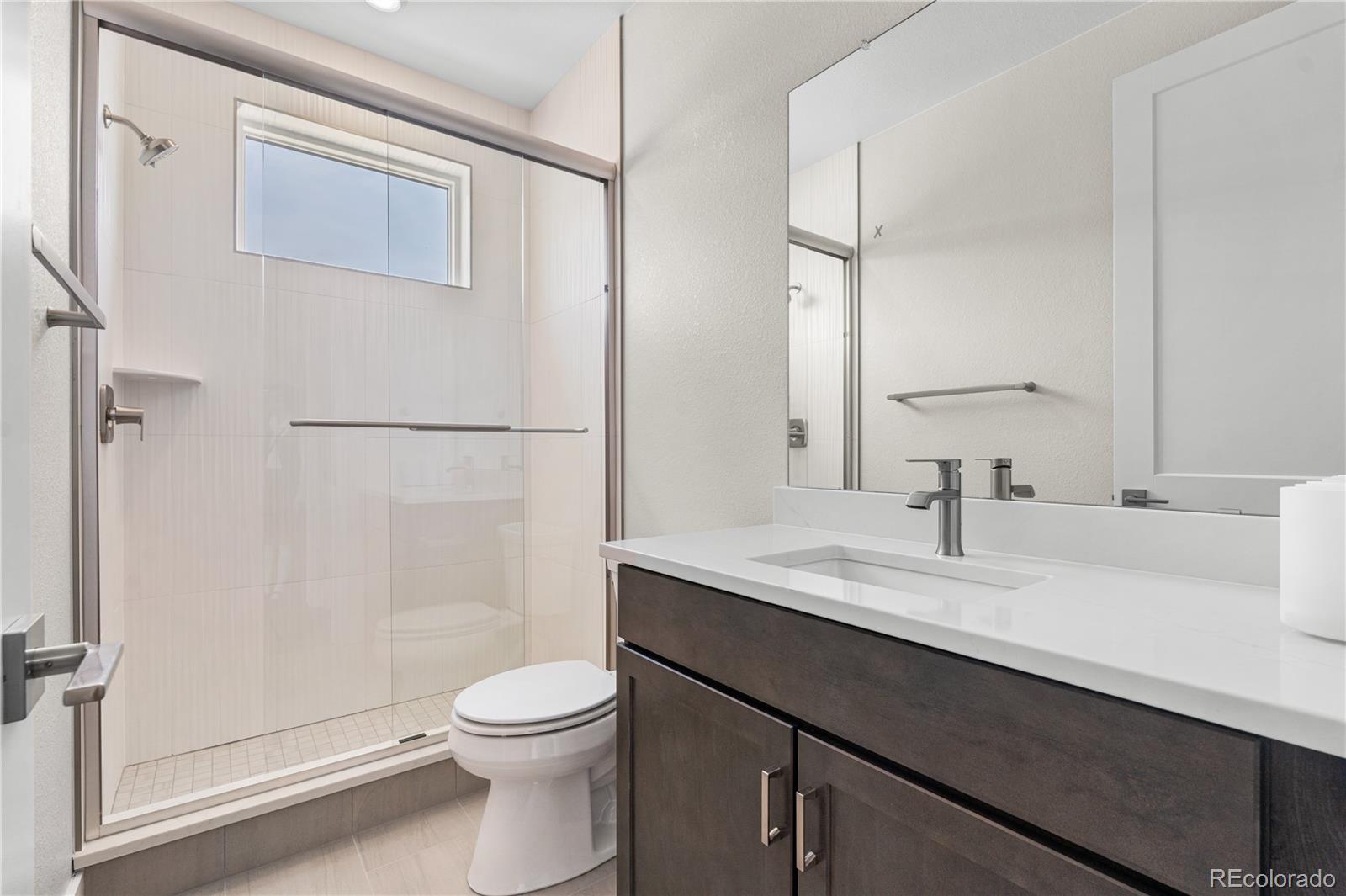 11208 Vibrato Lane Lone Tree, CO 80134 - Photo 23 of 40 a bathroom with a sink a toilet and shower