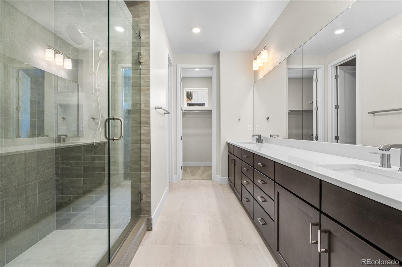 11208 Vibrato Lane Lone Tree, CO 80134 - Photo 24 of 40 a bathroom with a double vanity sink and mirror