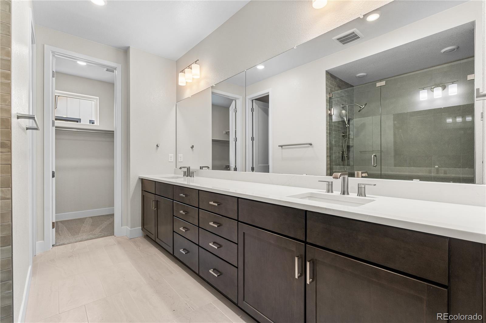 11208 Vibrato Lane Lone Tree, CO 80134 - Photo 25 of 40 a bathroom with double vanity sinks and a shower