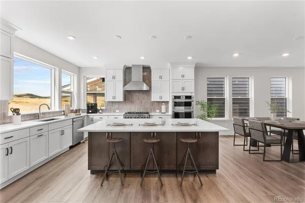 a large kitchen with cabinets table and chairs