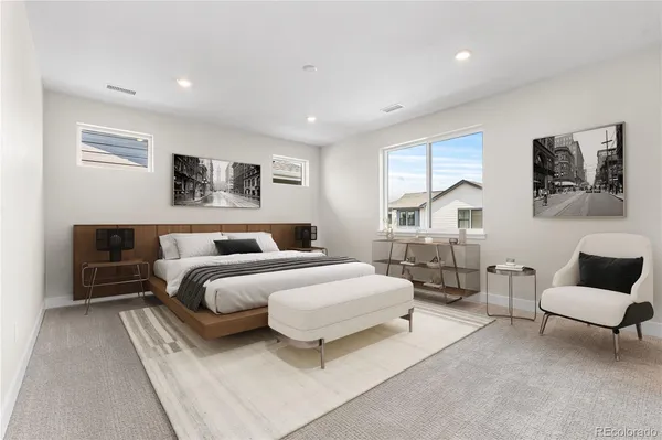 a spacious bedroom with a bed a couch and dresser