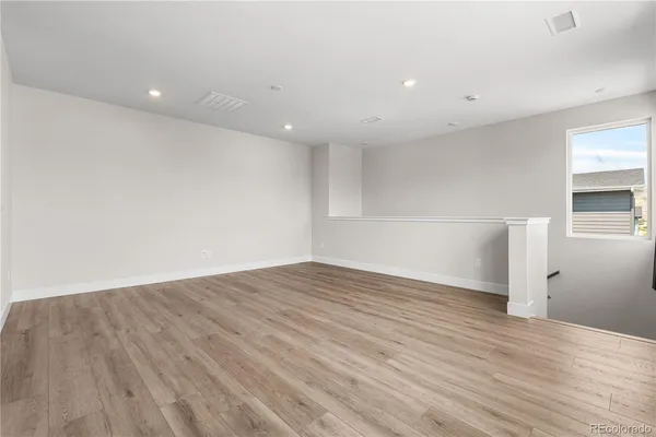 a view of empty room with wooden floor